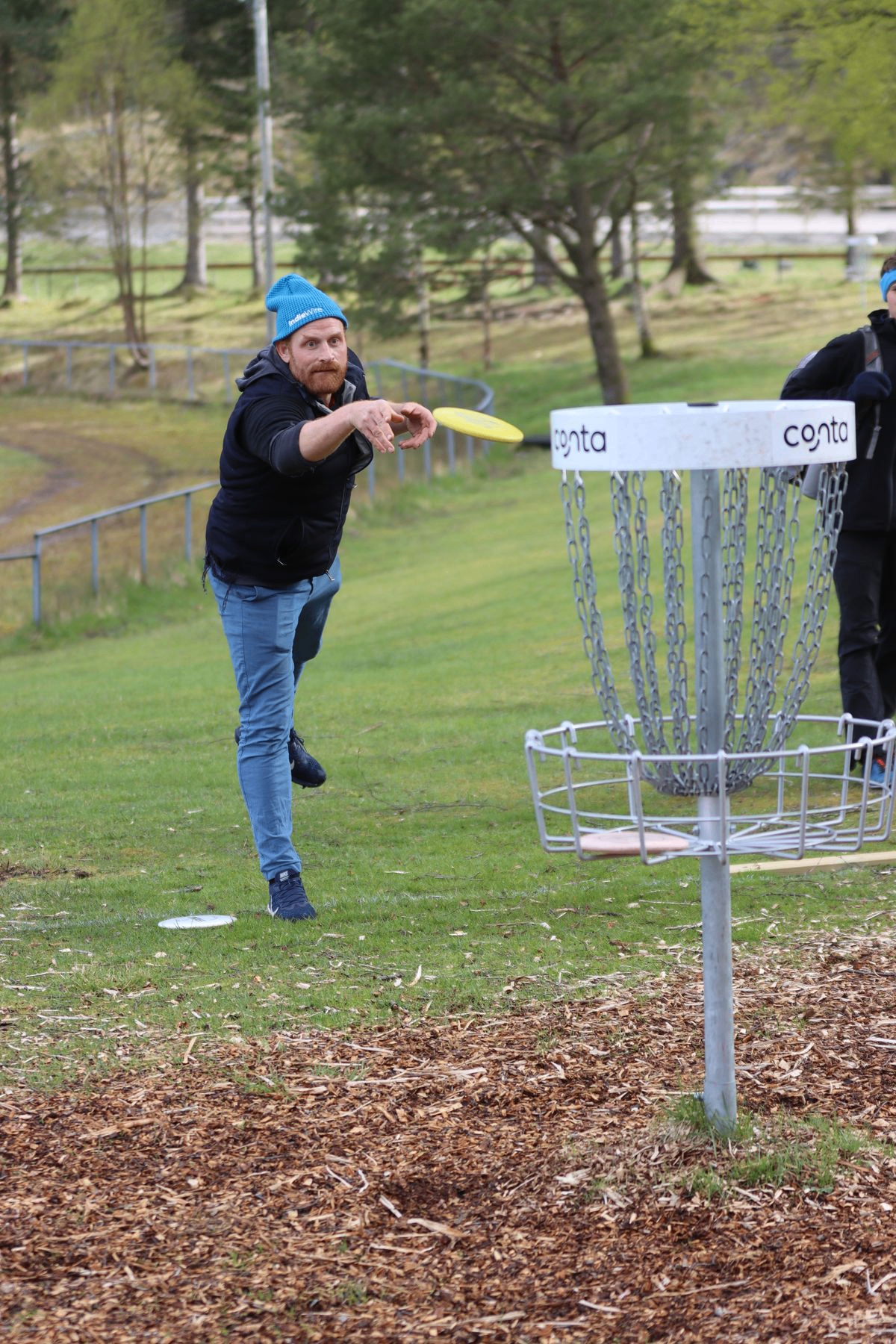 Spiller kaster på utslag i Vasset diskgolfpark — Conta-kurv